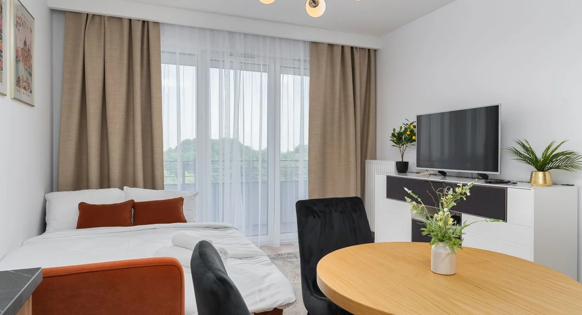 A bright modern studio apartment features a cozy living area with elegant decor.