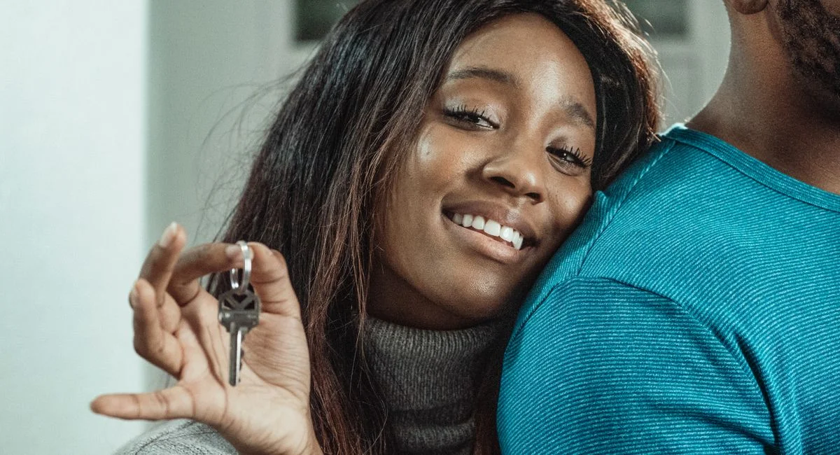 A joyful couple celebrating their new home purchase by holding keys.