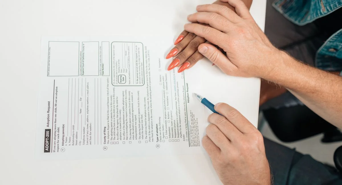 A couple fills out an adoption request form, highlighting commitment and future family planning.