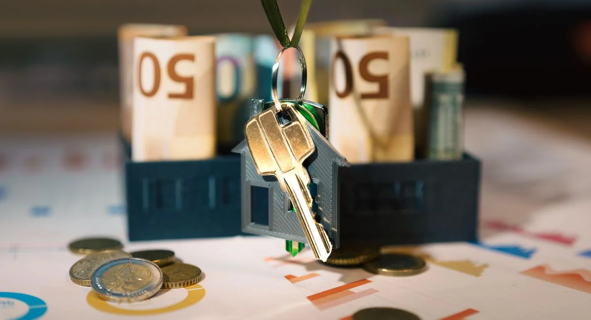 Keys hanging with money and charts, symbolizing real estate investment and financial planning.