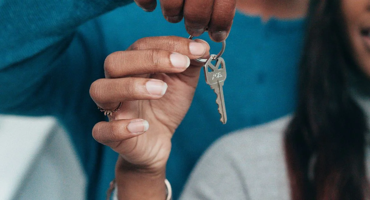 A couple holding a key, symbolizing a new home ownership or rental.