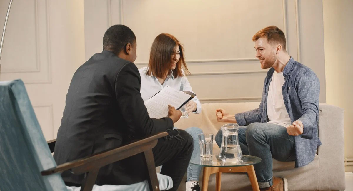 Three professionals engaged in a collaborative meeting in a modern office setting.