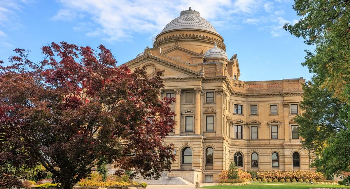 Elegant view of the Luzerne County Courthouse surrounded by autumn foliage under a clear blue sky.